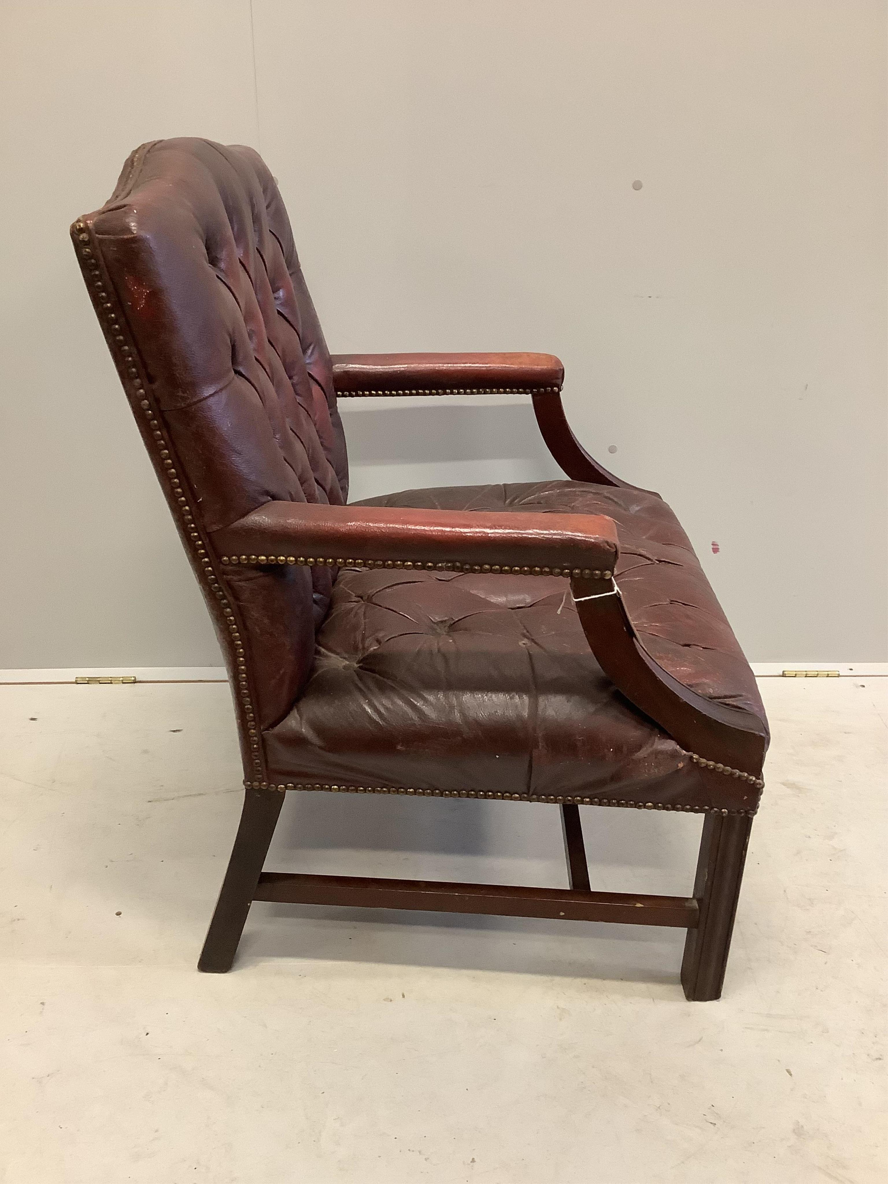 A George III style buttoned leather Gainsborough style chair, width 70cm, depth 61cm, height 94cm. Condition - fair